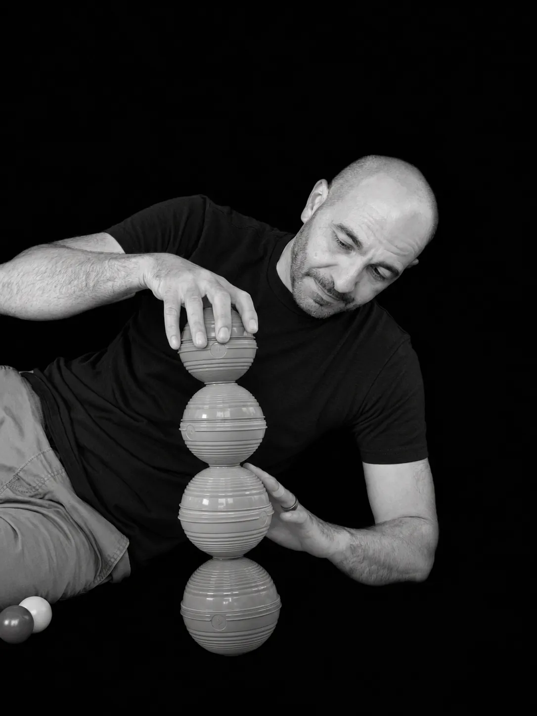 Joe Mikhail stacking a tower of balls, black and white